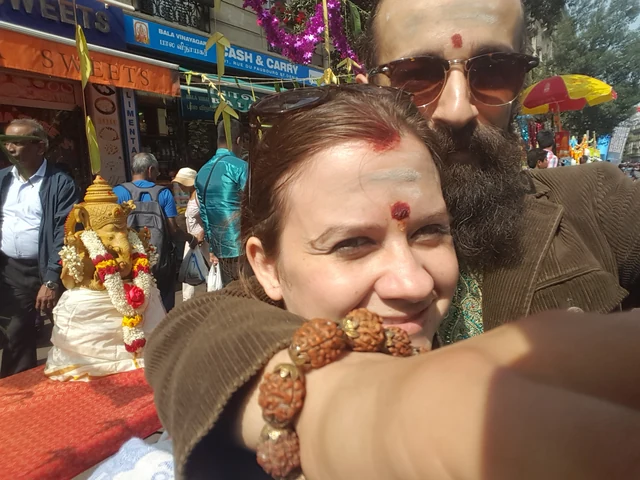 Two people close together among colourful market stalls.